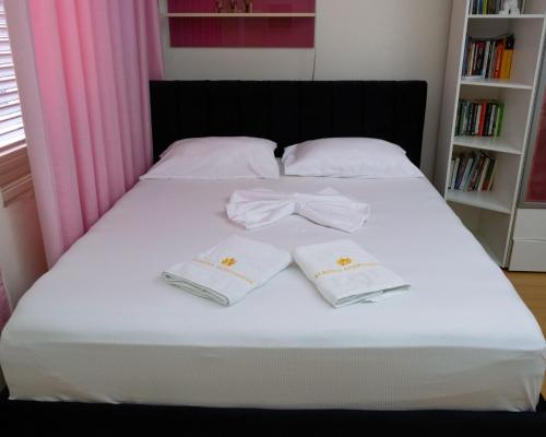 a bed with two white towels with a bow on it at Albjona Guesthouse 1 in Tirana