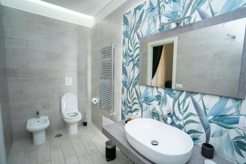 ナポリにあるMida's Boutique Roomsの白いトイレと洗面台のあるバスルーム