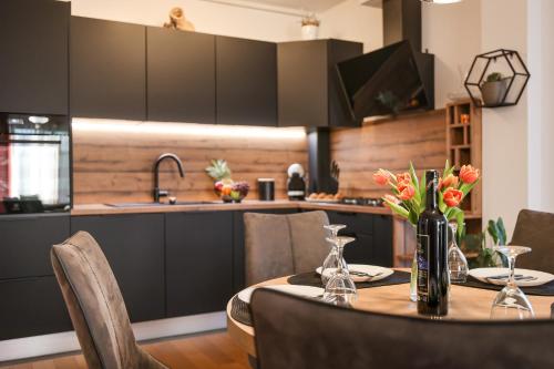 a dining room with a table with flowers in a kitchen at Luma Luxury Apartment with Jacuzzi in Zadar