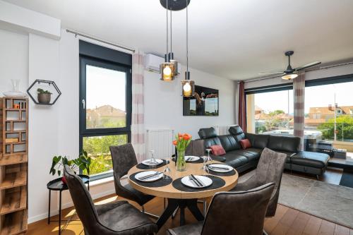 a living room with a table and chairs and a couch at Luma Luxury Apartment with Jacuzzi in Zadar
