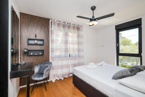 a bedroom with a bed and a desk and a window at Luma Luxury Apartment with Jacuzzi in Zadar