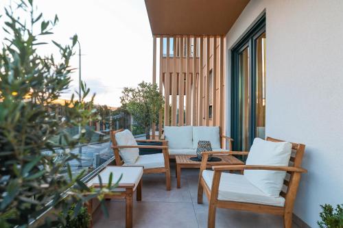 a patio with chairs and tables on a balcony at Luma Luxury Apartment with Jacuzzi in Zadar