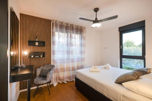 een slaapkamer met een bed, een bureau en een raam bij Luma Luxury Apartment with Jacuzzi in Zadar