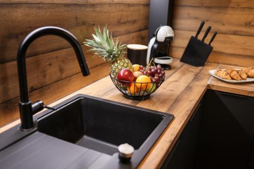 a kitchen counter with a sink and a bowl of fruit at Luma Luxury Apartment with Jacuzzi in Zadar