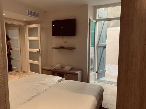 - une chambre avec un lit et une télévision murale dans l'établissement C098- Cannes - Suquet Bel appart - Grande Terrasse, à Cannes