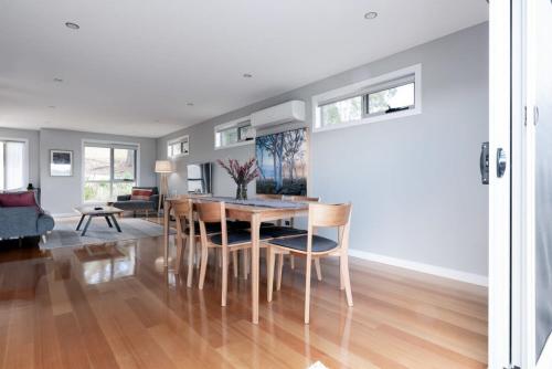 a dining room and living room with a table and chairs at Breathtaking Views with Parking in Trevallyn in Inveresk