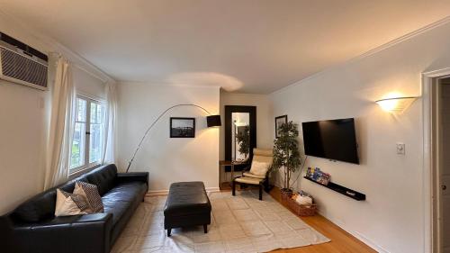 a living room with a black couch and a tv at Echo Park Hills in Los Angeles