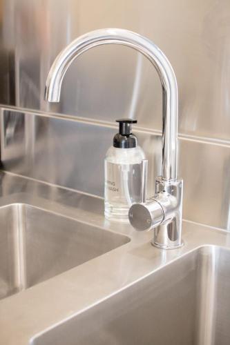 a sink with a soap bottle sitting on top of it at Cosy & Convenient: WiFi =& Parking in Kings Park