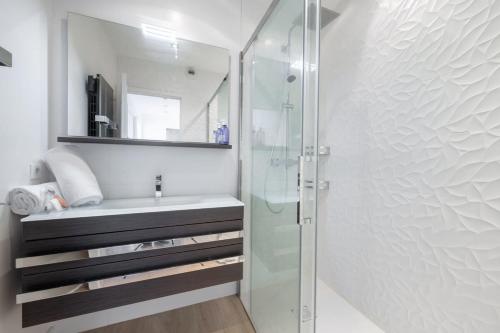 een badkamer met een glazen douche en een wastafel bij Magnifique vue mer panoramique in Vallauris