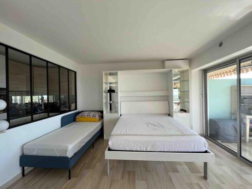 a bedroom with two beds and a large window at Magnifique vue mer panoramique in Vallauris