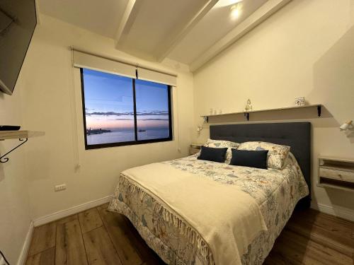 a bedroom with a bed and a large window at Moderno, iluminado y céntrico, Valparaíso in Valparaíso