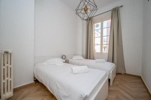 deux lits dans une chambre blanche avec une fenêtre dans l'établissement B027-Nice renovated apt near downtown - Cannes, à Cannes
