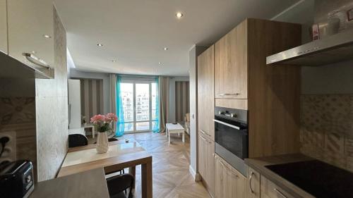 - une cuisine avec des placards en bois et une table fleurie dans l'établissement B018-Bright apartment with balcony - Cannes Croisette, à Cannes