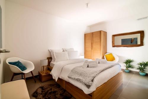 une chambre avec un grand lit et une chaise dans l'établissement A059-New apt with south facing - Terrace-Near the beach, à Antibes