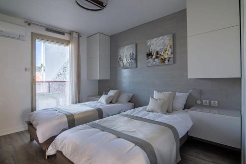 une chambre avec deux lits et une grande fenêtre dans l'établissement A031-Beautiful apt for 6 - Cannes close to the beach, à Cannes