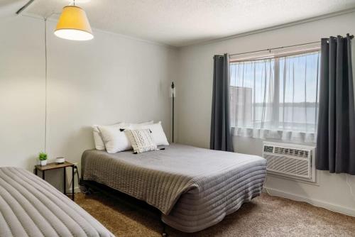 um quarto branco com uma cama e uma janela em 2 Lakeside Apartment Units in One at Fife Lake Lodge em Fife Lake