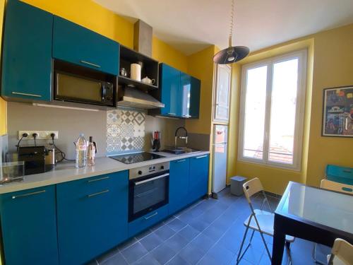 une cuisine avec des placards bleus et un sol bleu dans l'établissement A084-Welcoming apartment in Rue d'Antibes the heart of Cannes, à Cannes