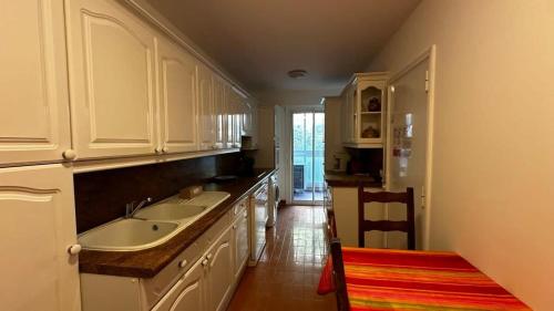 une cuisine avec des armoires blanches et un évier dans l'établissement A069-Apt in residence with pool and sea view - Cannes, à Cannes