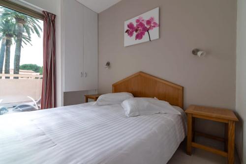 - une chambre avec un lit et une fenêtre avec un palmier dans l'établissement A042-Beautiful functional bright apt- Vallauris, à Vallauris