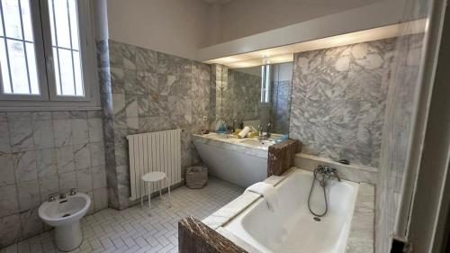 une salle de bain avec une baignoire, un lavabo et des toilettes dans l'établissement B011-Appartement familial - Proche de la plage, à Cannes
