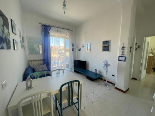 a kitchen and living room with a table and chairs at A un passo dal mare! in Piombino