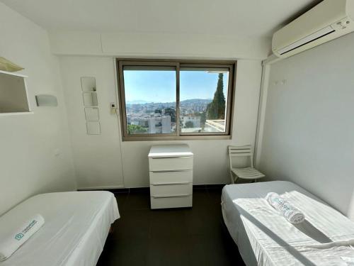 een ziekenhuiskamer met 2 bedden en een raam bij A013-Apt vue mer avec piscine et terrasse in Cannes
