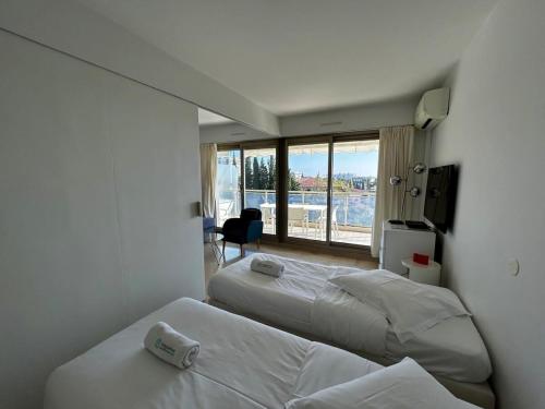 une chambre d'hôtel avec deux lits et une fenêtre dans l'établissement A018-Large studio with sea view swimming pool garage, à Cannes