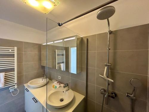 une salle de bain avec un lavabo et une douche avec un miroir dans l'établissement A018-Large studio with sea view swimming pool garage, à Cannes