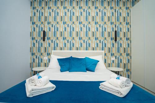 a bedroom with a bed with blue pillows and towels at Mida's Boutique Rooms in Naples