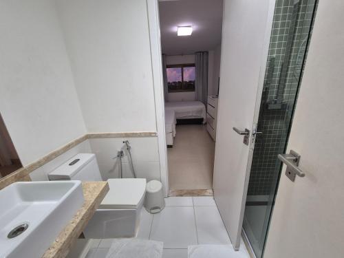 a bathroom with a toilet and a sink and a shower at Condominio Mediterraneo - Iberostate in Praia do Forte
