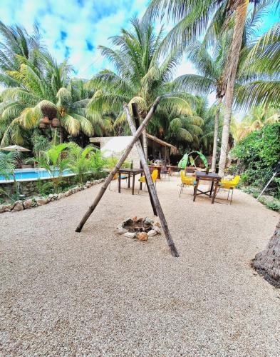 a swing set on a beach with palm trees at Casa Maria Bonita Hotel & Restaurant El Cuyo by Spot Rentals in El Cuyo