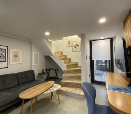 a living room with a couch and stairs at Kaleo Chios Luxury Apartments in Chios