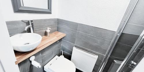 a bathroom with a sink and a toilet at Cozy Room in Modern House near Nottingham in Nottingham