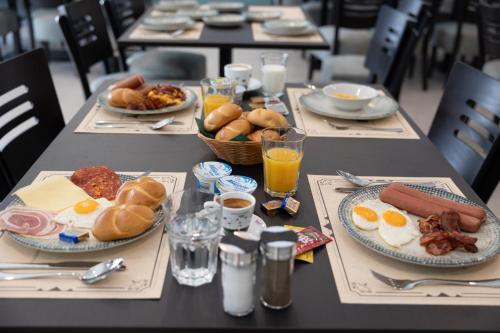 una mesa cubierta con platos de comida y bebida para el desayuno en Rooms Rebolj, en Osijek