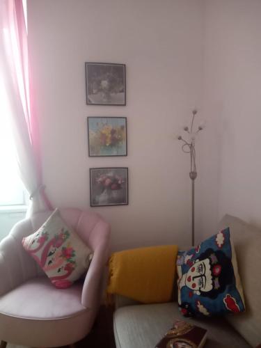 uma sala de estar com um sofá e algumas fotografias na parede em Thorntree Street Edinburgh em Edimburgo