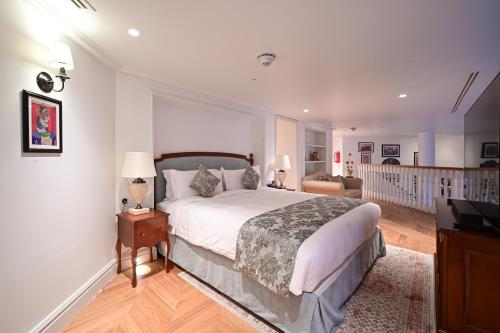 una camera con un grande letto e una scala di 21 High Street Residence a Doha