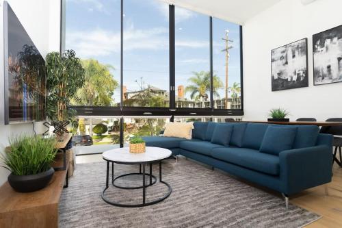 a living room with a blue couch and a table at Bright and Trendy - Panoramic - Chic - Prime Location in San Diego
