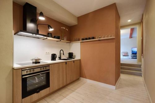 La cocina está equipada con fogones, fregadero y horno. en Apartment Mosel-Sauna-Terrasse, en Ürzig