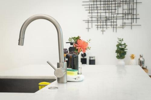 a kitchen counter with a sink with a bottle of alcohol at Bright and Trendy 2-story Bankers Hill Condo in San Diego