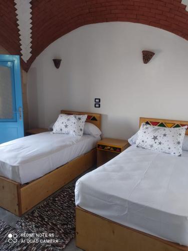two beds sitting next to each other in a bedroom at Nubian Heights in Aswan