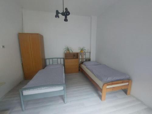 a room with two twin beds and a dresser at Dom v centre Piešťan in Piešťany