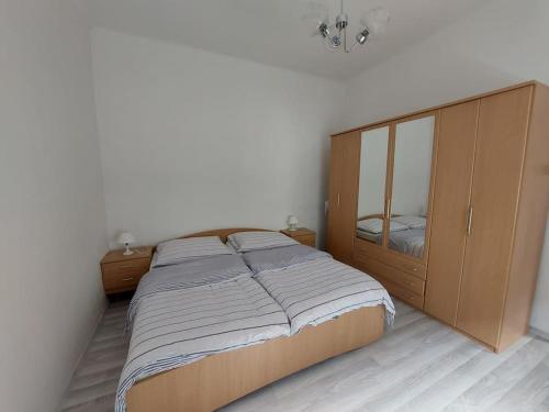 um quarto com uma cama grande e um armário de madeira em Dom v centre Piešťan em Piešťany
