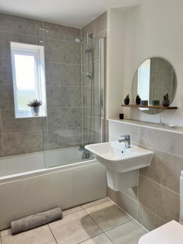 a bathroom with a sink and a shower and a tub at Chocolate Quarter Townhouse in Keynsham