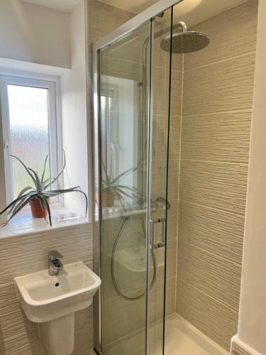 a bathroom with a glass shower and a sink at Chocolate Quarter Townhouse in Keynsham