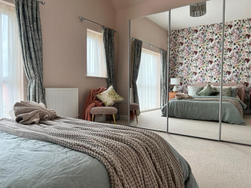 a bedroom with a mirror and a bed and a chair at Chocolate Quarter Townhouse in Keynsham
