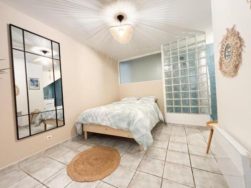 - une chambre avec un lit et un miroir dans l'établissement Appartement T2 en centre-ville, à Martigues