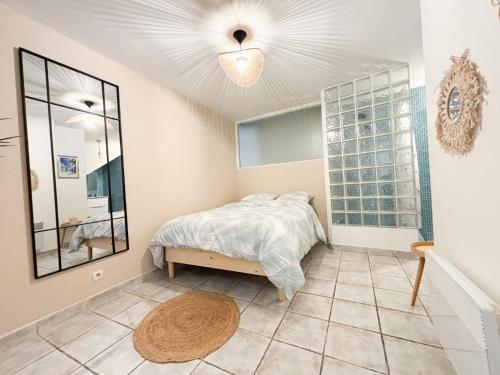 une chambre avec un lit et un miroir dans l'établissement Appartement T2 en centre-ville, à Martigues