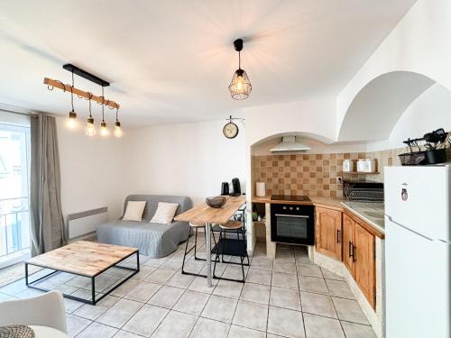 une cuisine et un salon avec une table et un canapé dans l'établissement Appartement T2 en centre-ville, à Martigues