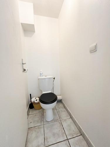 La salle de bains est pourvue de toilettes et d'un siège noir. dans l'établissement Appartement T2 en centre-ville, à Martigues