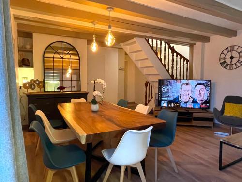 a dining room with a table and a tv at Sara Home in Chennevières-sur-Marne